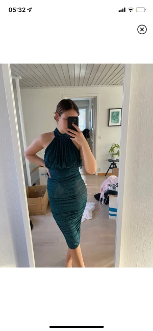 Grön klänning - Smaragdgrön klänning som skimrar vackert. Använd en gång av tidigare ägare. Storlek 38.