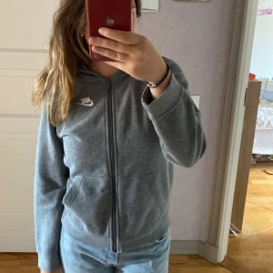 Nike tröja - Grå Nike kofta i helt nytt sick.  Säljs då den aldrig kom till användning. Inga skador eller fläckar heller. Är en storlek L i barnkläder så den passar en Xs & S. Hör av er vid intresse är flexibel med pris 