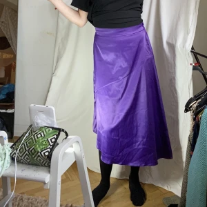Lila glansig kjol - Tunn och glansig med lite tyngd. Förmodligen polyester. Lite nopprig vid kjolslutet.  Skicka DM vid frågor. ☆．。･