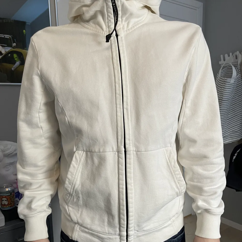 Säljer denna vita ziphoodie från C.P. Bra skick, inga skador eller missfärgat. Liten i storlek. Nypris: 2300kr (jag är 178cm). Hoodies.