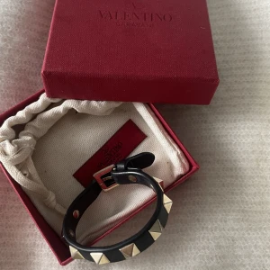 Svart valentino armband - Valentino Garavani Rockstud Leather Bracelet. Köpt för 3 000 kr. I väldigt fint skick och har inga stora defekter. Ynka små repor på nitarna men inget man ser. 