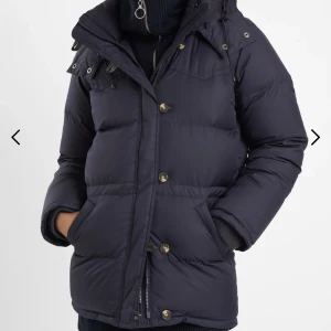 Boomerang-jacka  - Dunjacka från boomerang. Jättevarmt och fin. Luva saknas. Färgen är mellan mörkblå och svart. Man kan justera midjan beroende på om man vill ha en rak modell eller figursydd. 