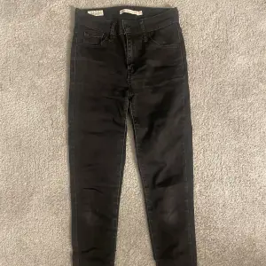 Svarta skinny jeans från Levis.  Modellen heter 720 high rise super skinny. Dom är lite slitena bak på fickan som visas i bilden.
