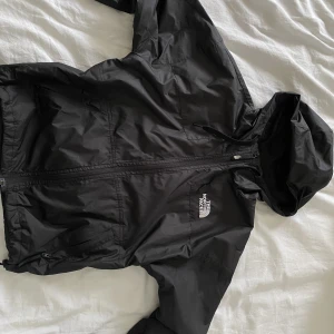 North Face vindjacka  - En snygg vindjacka från North Face. Den har ett litet hål på ryggen ( tredje bilden) men luvan räcker oftast hålet. Storlek S