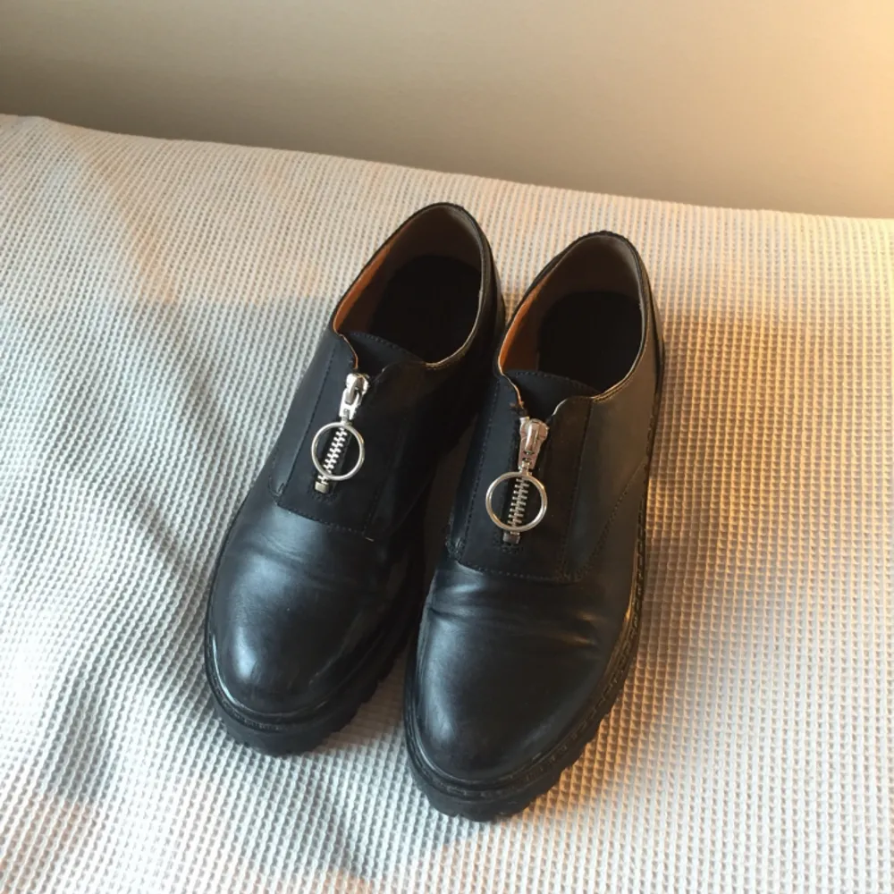 svarta skor i fakeskinn med blixtlås. använda lite men de enda fel som syns är slitningar på insidorna av foten på båda skorna (se foton), därav priset. annars bra skick!. Skor.