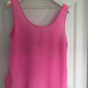 Jättefint rosa linne i tunt material från Gina Tricot. Fin rosettdetalj på ryggen. Är en storlek M och passar S/M. 