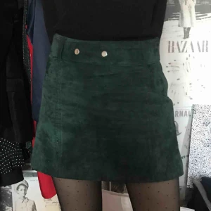  - Kjol i smaragdgrön färg i mocka från Zara. Nypris 500. Knappt använd. Silvriga knappar. 