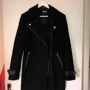  - Stilren och klassisk svart kappa, perfekt till hösten! Använd under en höst, mycket bra skick!