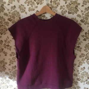  - Längre magtröja i sweatshirt-tyg. Fin vinröd färg. Köpt på Beyond retro. Passar XS-L.