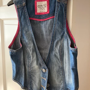 Figursydd jeansväst från Esprit - Figursydd jeansväst med fin passform. Om den ska skickas på posten tillkommer fraktkostnad. Betalas med Swish. 