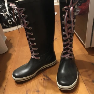 Gummistövlar Viking stl 40 - Oanvända höga gummistövlar med snörning av märket viking. Inköpta för längesedan och aldrig använda. Kan mötas upp eller så står köparen för frakt. 