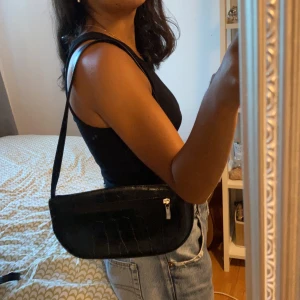 Svart baguetteväska  - Vintage baguetteväska i krokodil skin(inte äkta) i silverdetaljer. Frakt ingår inte i priset. Kan mötas upp i Stockholm söder.