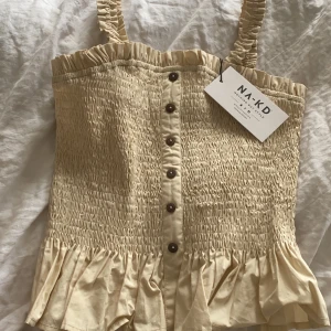 Söt topp - Super sött linne från NAKD. Aldrig använd eller testad så prislapp kvar. Säljs pga att den ej används.