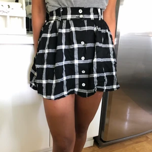Kort plaidkjol  - Svart och vit plaidkjol som är fyndad på secondhand. Tyvärr fattas en av knapparna. Pris: 30 kr, köparen står för frakten. 