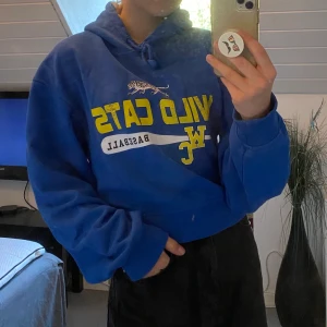 Blå hoodie med tryck - En blå hoodie som är något croppad med tryck på framsidan. Sitter något oversized men är sjukt snygg och väldigt bekväm. 
