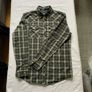 Rutig skjorta - Rutig skjorta i mörkgrönt. Den är knappt använd och är storlek L. Snyggt över T-shirt eller knyta runt höfterna!