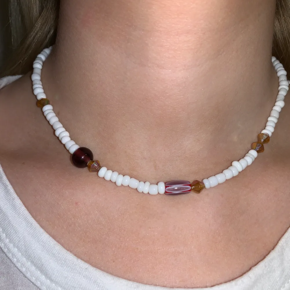 Vitt pärlhalsband med orangebruna pärlor🤍🤩🧡💫🥺 halsbandet försluts med lås och tråden är elastisk . Accessoarer.