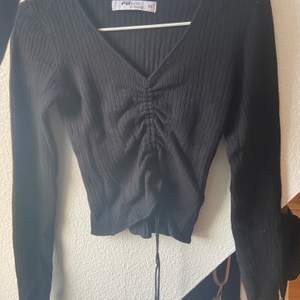 Superfin svart tröja där det finns snören man kan dra upp och få mer kroppad, lite v ringad, frakten är 60 kr💕