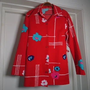 Vintagekavaj - Så cool vintagekavaj/innejacka/kofta eller vad man nu vill kalla den! Klarröd färg med fint mönster. Hällor i sidorna och spetsig krage a la 70s. Bedömmer storleken till M🏵️