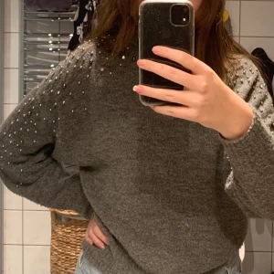 Grå tröja från hm - Grå tröja med pärlor på armarna från hm som ny har nästan aldrig använt, varm och mysig! Dock stor i storleken.                                                                                   Köparen står för frakt!!!            