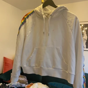 Hoodie från monki - Cool hoodie från monki med regnbågsdetaljer på sidan! Är en liten fläck på framsidan!