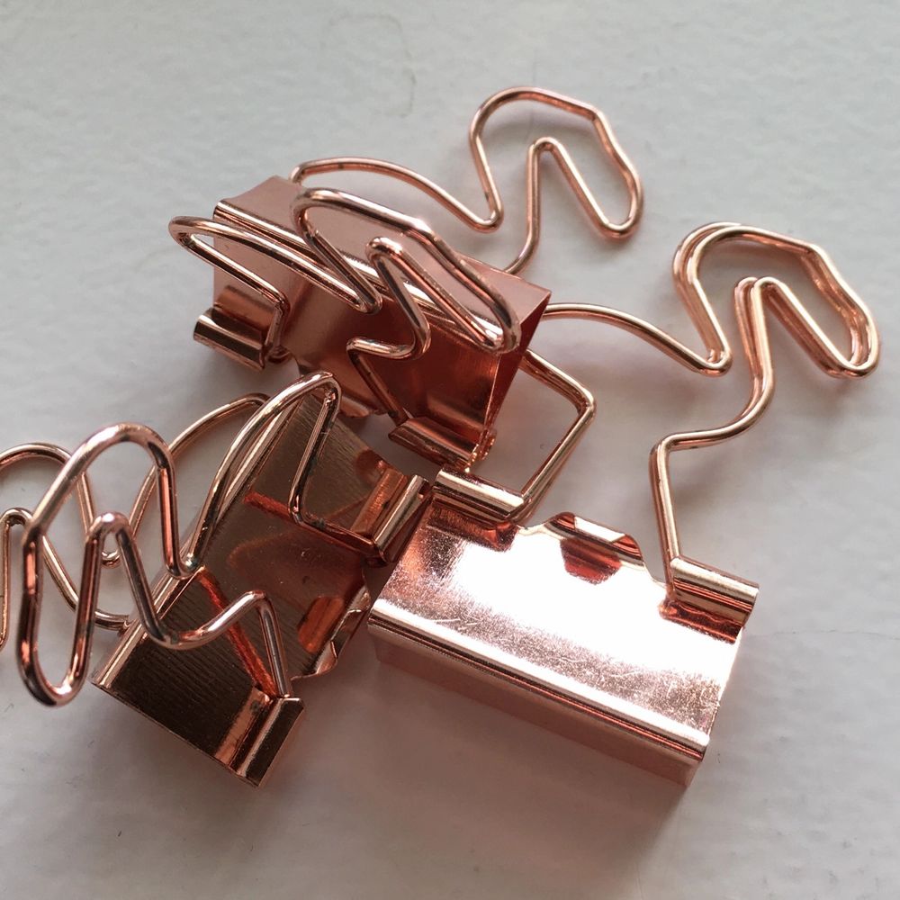 Klämmor i roséguld som ser ut som flamingos. Väldigt praktiska eftersom att de kan användas till allt. Samla ihop dina kvitton eller organisera viktiga papper eller häng upp en tavla med hjälp av dem. Jag använder inte just dessa. Därför säljer jag dem. . Accessoarer.
