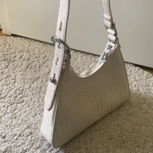 Vit/Créme-färgad väska - Superfin väska, helt oanvänd (nyskick). Unik form och väldigt fin till alla tillfällen! Säljer då jag har alldeles för många väskor och behöver rensa.💕💕 (Köpt för 399kr, men säljer nu för 150) Pris kan diskuteras🥰