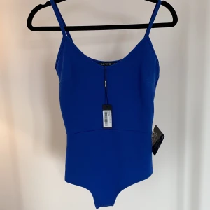 Body  - Fin figursydd body från NLY One, i ett tjockare strechigt tyg. Dålig kvalitet på bilden från Google men gick inte att hitta bättre. Aldrig använd, prislapp kvar!