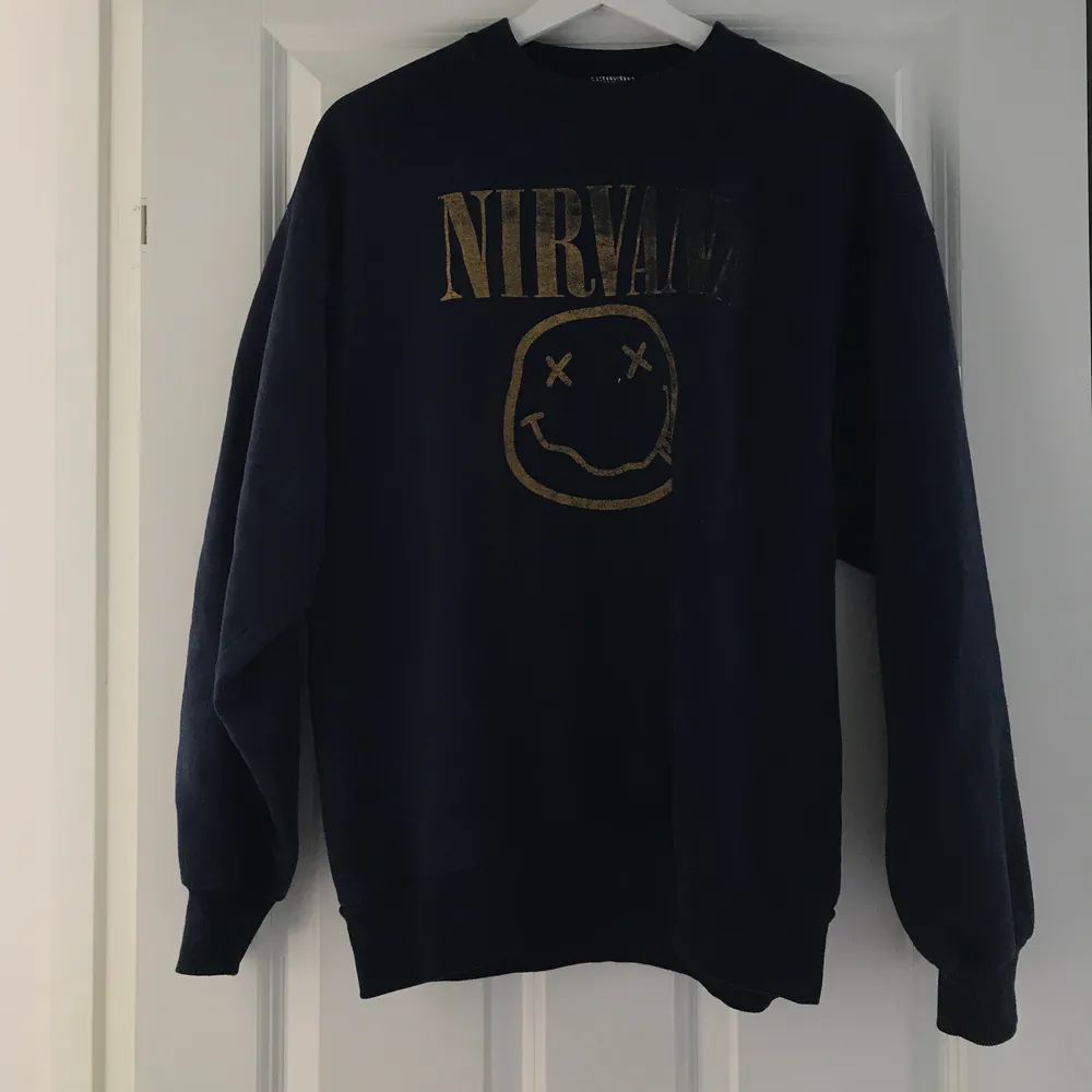 En vintage Nirvana sweatshirt i en mörkblå färg. Köpt i Köpenhamn. Jag som är S bär den lite oversized. Jag skulle säga att den passar XS-M.. Toppar.