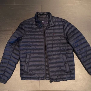 Jacka  - En tunnare jacka från Tommy Hilfiger i en marin blå färg 
