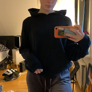 Svart hoddie med fickor på sidan - En jätte fin svart hoddie med bra passform. Den har två små fickor på varje sida vid ”sido” sömen. Luvan sitter bra, har dock inga snören. Möts i Karlstad eller skickas. Ganska liten i storleken