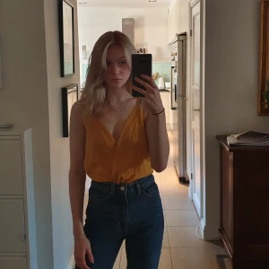 Body - Orange body i löst material. Sitter bättre om den passar... knappen vid brösten är lite lös men annars bra skick. Frakt tillkommer, kan även mötas upp i Stockholm.