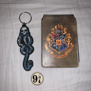 Harry Potter, merch - Harry Potter nyckelring (20kr), Hogwarts/Gryffindor korthållare (20kr), Knapp (såld). Nyckelringen och korthållaren tillsammans = 35kr 