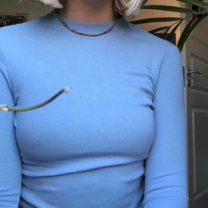  - En fin blå ribbad tröja med halv polo 