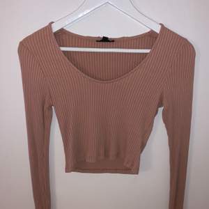 Detta är en beige/rosa långärmad tröja. Den är rätt så tight och ganska kort. Det är storlek 36 och rätt bra skick!