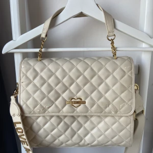 Moschino  - Säljer nu min moschino väska beige, nypris 4500;- 😀 lite skavsår på väskan dära priset, annars mycket snygg och stort utrymme. Band ingår i väskan, är avtagbart;) kan tänkas sänka priset vid mycket snabb affär.