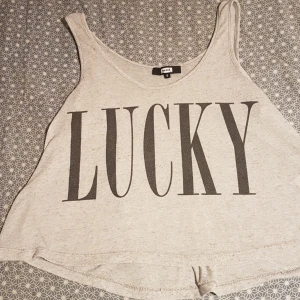 Ett grått lime med text. - De här et tljus grått lime med en liten text där dem står Lucky. 