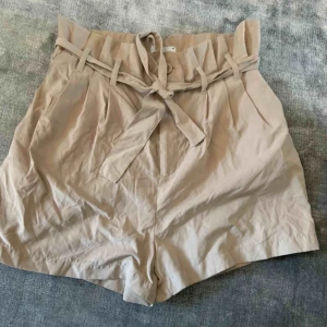  - Beiga knytshorts🌟 Paperbag modell, går att justera i midjan med bandet. Skrynkliga på bild då de legat undanvikta. 