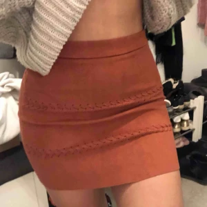  - Superfin kjol i kopparfärg med två ”flätor” i fram. 