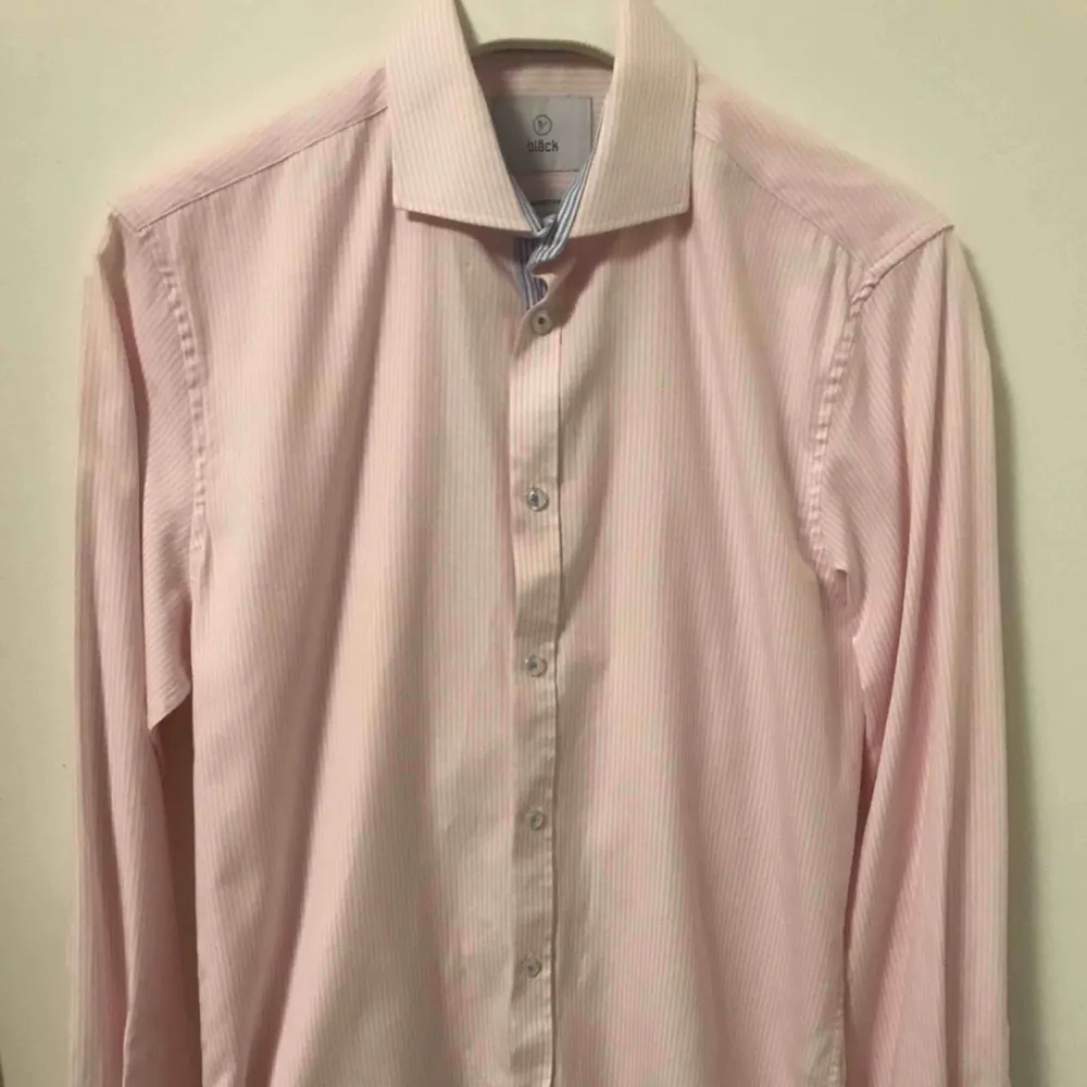 Snygg rosa skjorta med vita ränder från Bläck. Enbart använd en gång under min student, men har sen dess inte kommit till användning då jag har växt ur den. Storleken är small. Kan fraktas mot avgift.. Skjortor.