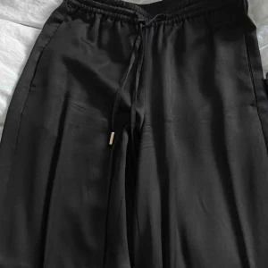  - Kostymbyxor från H&M, i glansigt material, utsvängda Säljer då jag tyvärr inte får på mig dem längre:(  