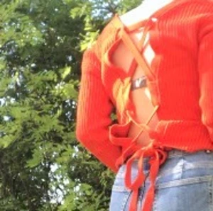 Stickad tröja - Röd styckad tröja med knyt detalj i ryggen, v-ringad urringning fram. Aldrig använd. Möts på Söder eller Hägersten eller så står köparen för frakt!