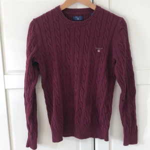 Kabelstickad GANT tröja. (S) - Kabelstickad GANT tröja. Tröjan är i bra skick då den knappt används. Färgen är en burgundy röd/vinröd.
