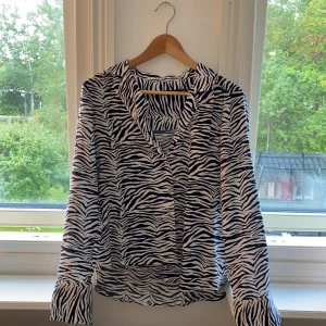 Skjorta med zebramönster - Asball skjorta med zebramönster från BikBok. Storlek XS. Nästan aldrig använd. Nypris: 299kr. Jag säljer för 99kr. Kan mötas upp i Gävle, annars tillkommer frakt.  