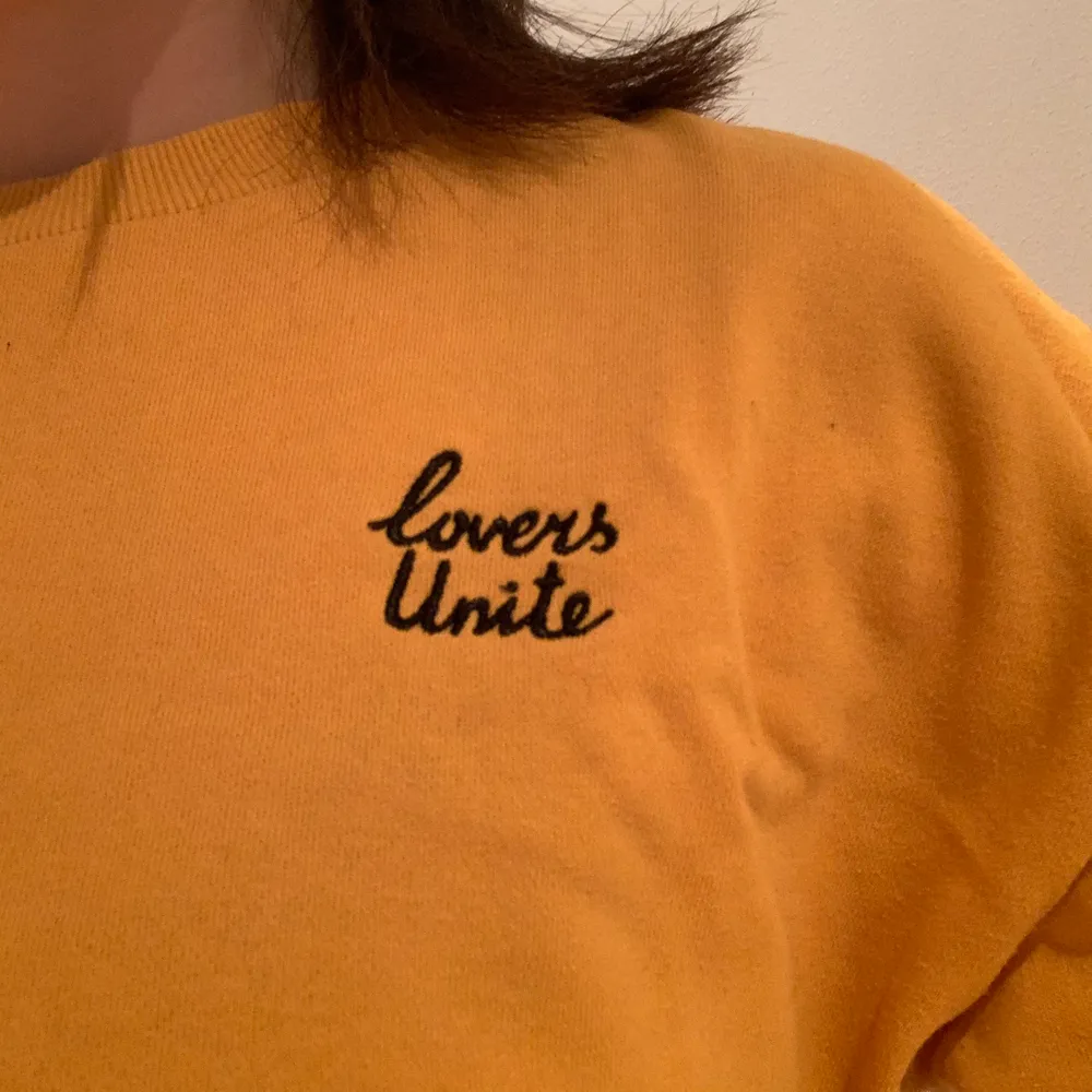 En gul sweatshirt från H&M med broderat ”lovers unite”. Använd och är lite nopprig men det syns inte så mycket. Frakt står köparen för . Tröjor & Koftor.