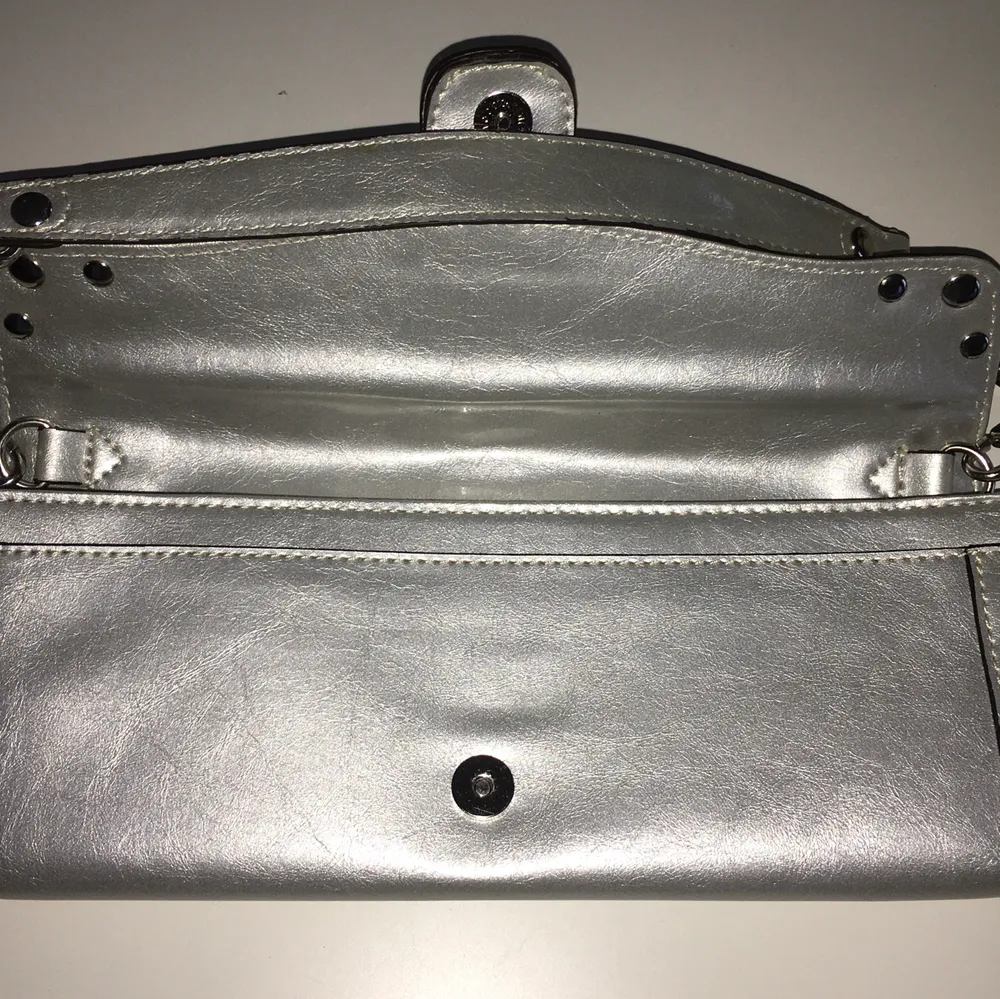 Kathy van Zeeland silver handväska i toppskick.mått: 28cm x 12cm .har många praktiska fack både med och utan dragkedja. . Väskor.