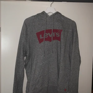 Grå hoodie - En grå Levis hoodie, har använts ganska mycket men är i bra skick