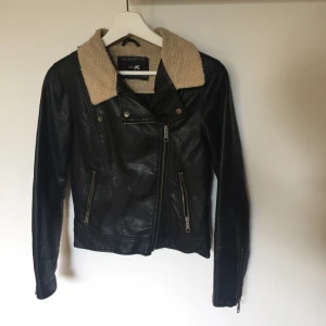  - Svart (Fake) skinnjacka med luddig krage och dragkedja. Från JC