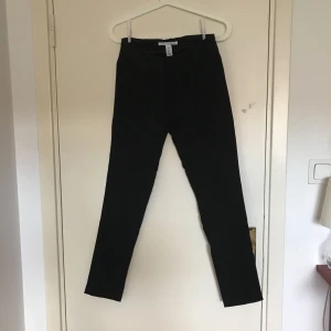  - Ett par kostymliknande byxor som endast har använts max 2 ggr. Snygga till fest eller till vardags. Stängs med knapp och en slags hake. Den har två fake fickor i bak.   Frakt ingår inte i priset.
