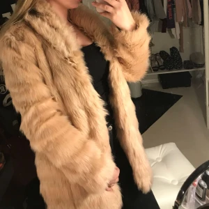  - Lång jacka med fusk päls. Bara använd en gång, var snäppet för stor för mej. Fodrad och mycket varm. 